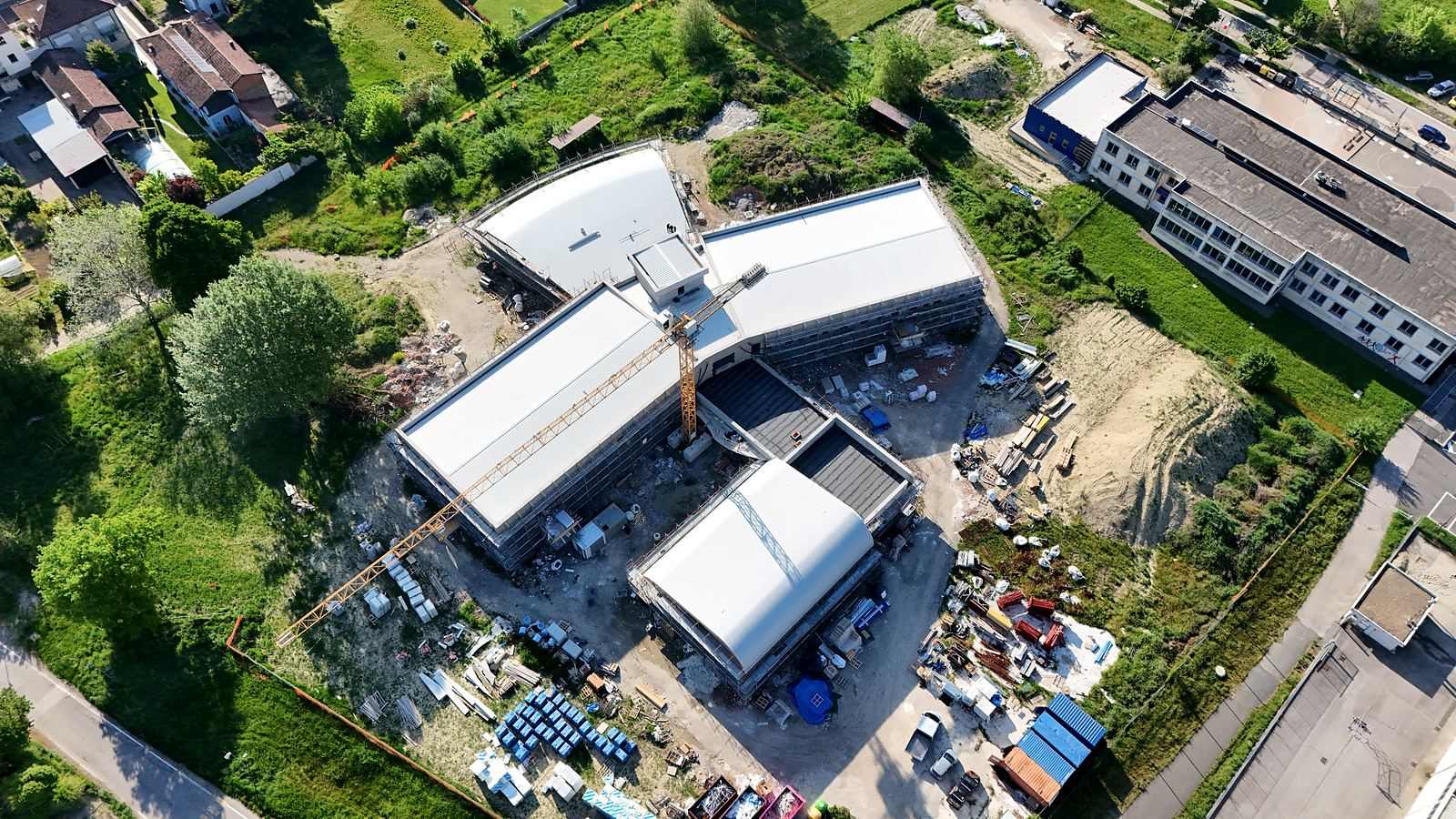 Vista aerea di un cantiere con gru e nuove coperture metalliche in posa
