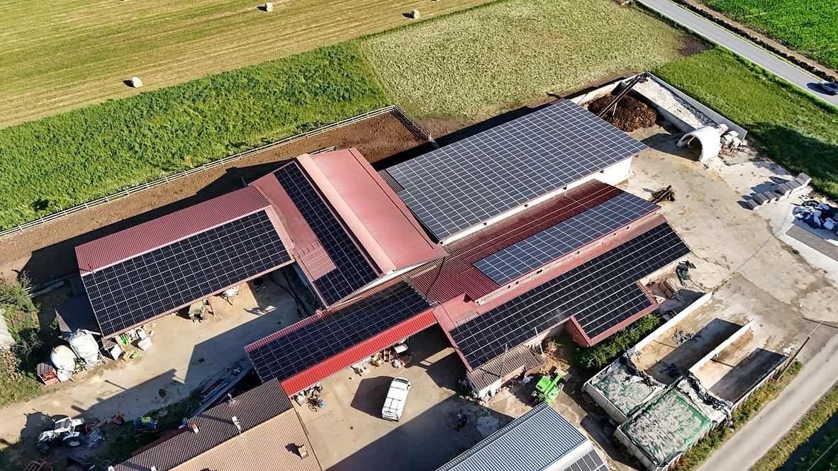 Vista aerea di un complesso agricolo con coperture metalliche e impianto fotovoltaico