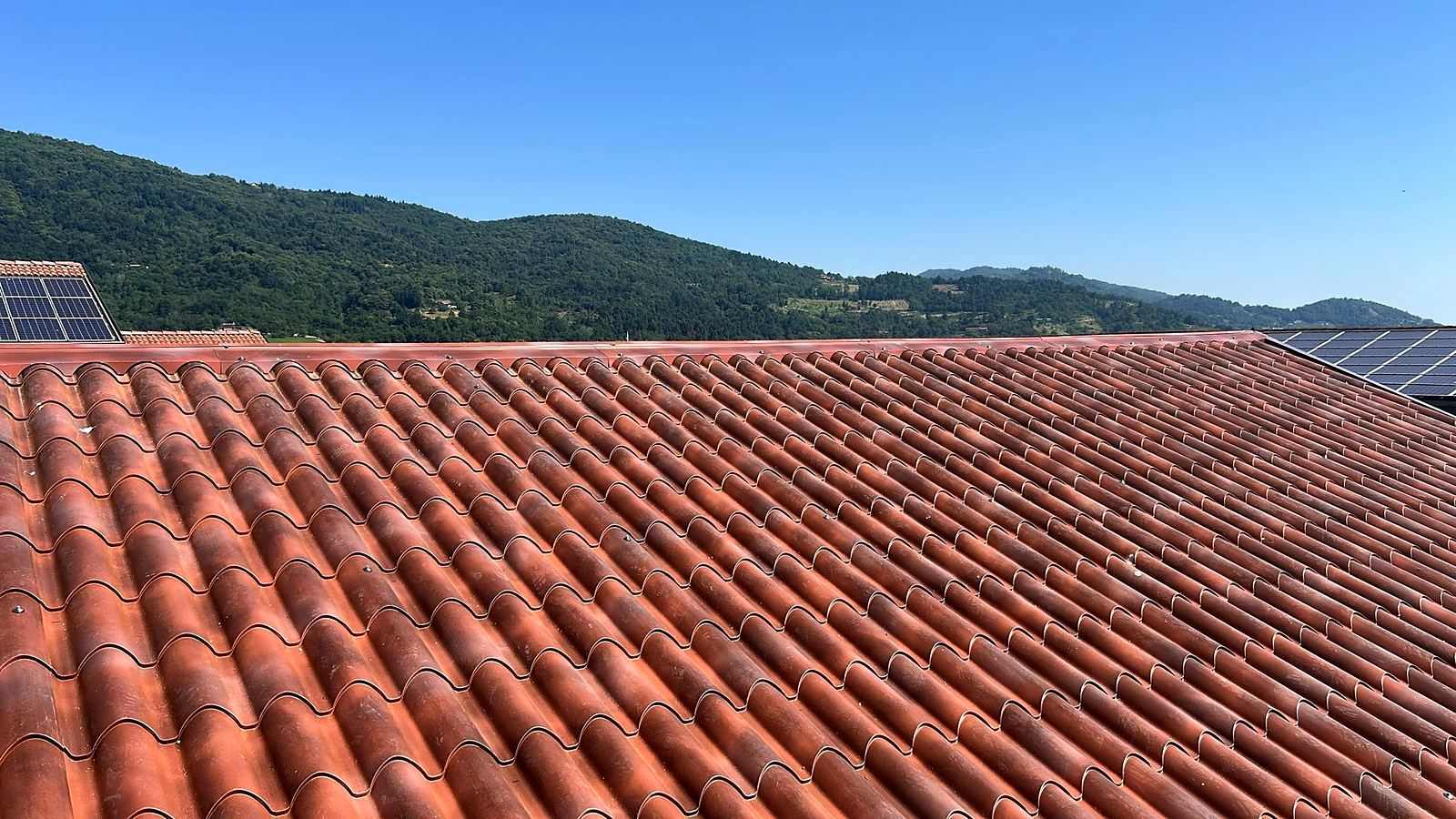Manto di copertura in lamiera con finitura finto coppo, con le colline sullo sfondo